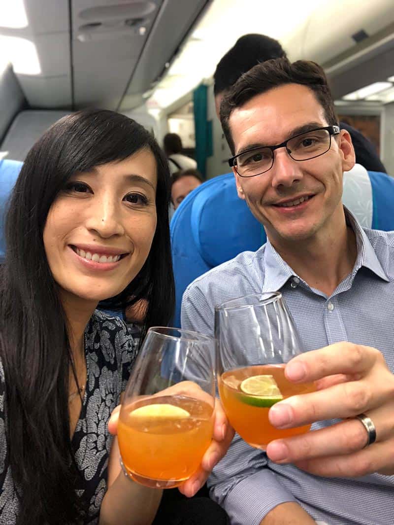 Jason and Jessica cheers drinks in Air Tahiti Nui airlines business class.